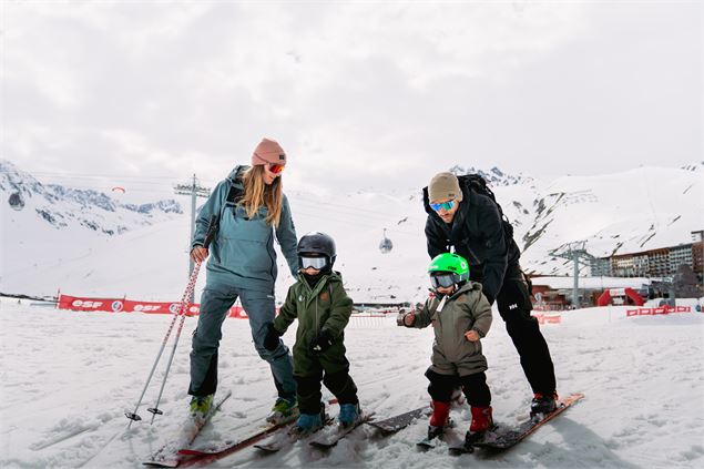 Jeune couple avec leurs deux enfants en bas de la piste du Rosset - Gregoire Fauquenoi