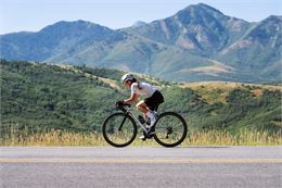 Femme Cycliste qui descend sur une route de montagne - Freepik