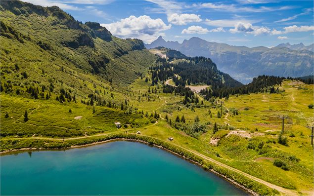 Vue en drone du lac de Vernant sur la chaîne de montagne des Aravis - OT Flaine-Candice Genard