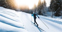 Skieur sur une piste de ski nordique au crépuscule au Grand-Bornand - C. Hudry