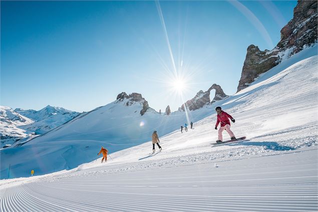 Des skieurs et snowboardeurs dévalent la piste bleue Corniche, au pied de l'Aiguille Percée - andypa