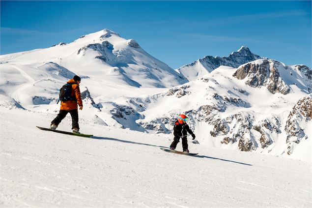 Un père et son fils en snowboard avec la Grande Motte en arrière-plan - andyparant.com
