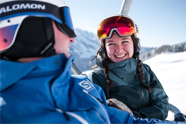 Couple de skieurs en télésiège sur le domaine de ski alpin du Grand-Bornand - T.Shu
