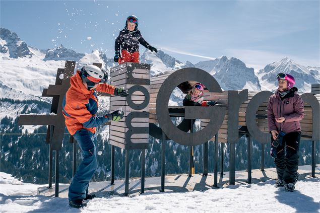 Famille de skieurs sur le domaine de ski alpin du Grand-Bornand, se lançant des boules de neiges fac