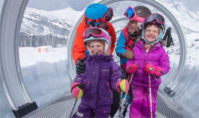 Famille sur le tapis de l'Alpage Express, sur les espaces débutants du domaine skiable du Grand-Born