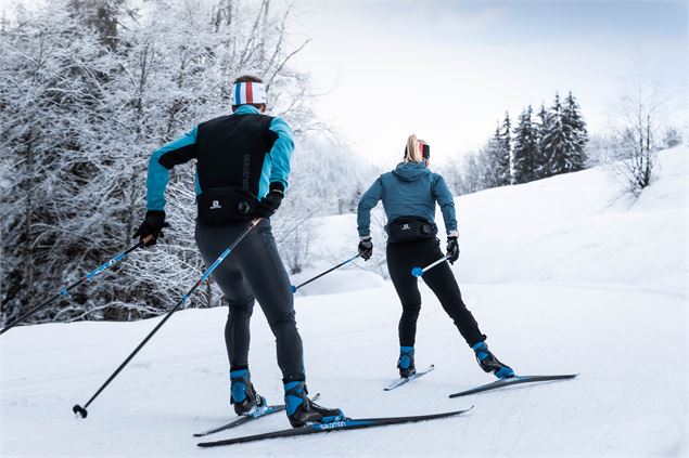 Deux skieurs de dos sur une piste de ski nordique au Grand-Bornand - C. Hudry