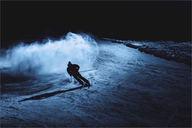 Skieur descendant une piste ouverte en nocturne sur le domaine skiable alpin du Grand-Bornand - P.Gu
