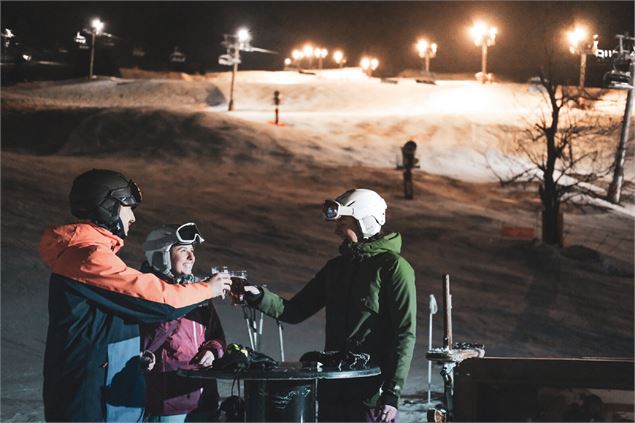 Groupe d'amis trinquant au pied des pistes du domaine de ski alpin ouvertes en nocturne - P.Guilbaud