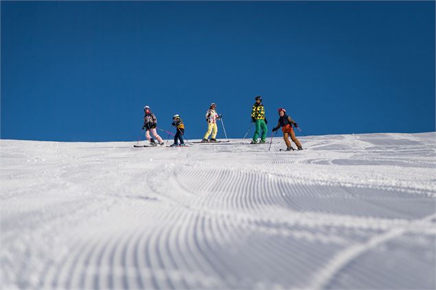Jeune couple skiant avec leurs deux enfants sur la piste primevère à valloire - Thibaut Blais / Vall