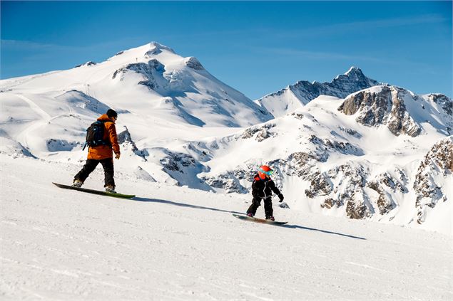 Père et fils en snowboard avec la Grande Motte en arrière plan - andyparant.com