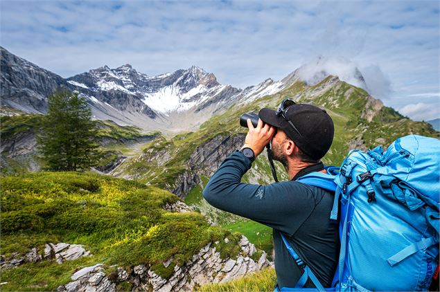 Personne qui regarde aux jumelles les massifs - OT Samoens - mathilda Manzi