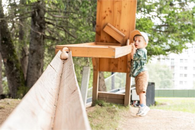 Enfant qui regarde la boule rouler sur le parcours - OT Flaine - N.Ladrix