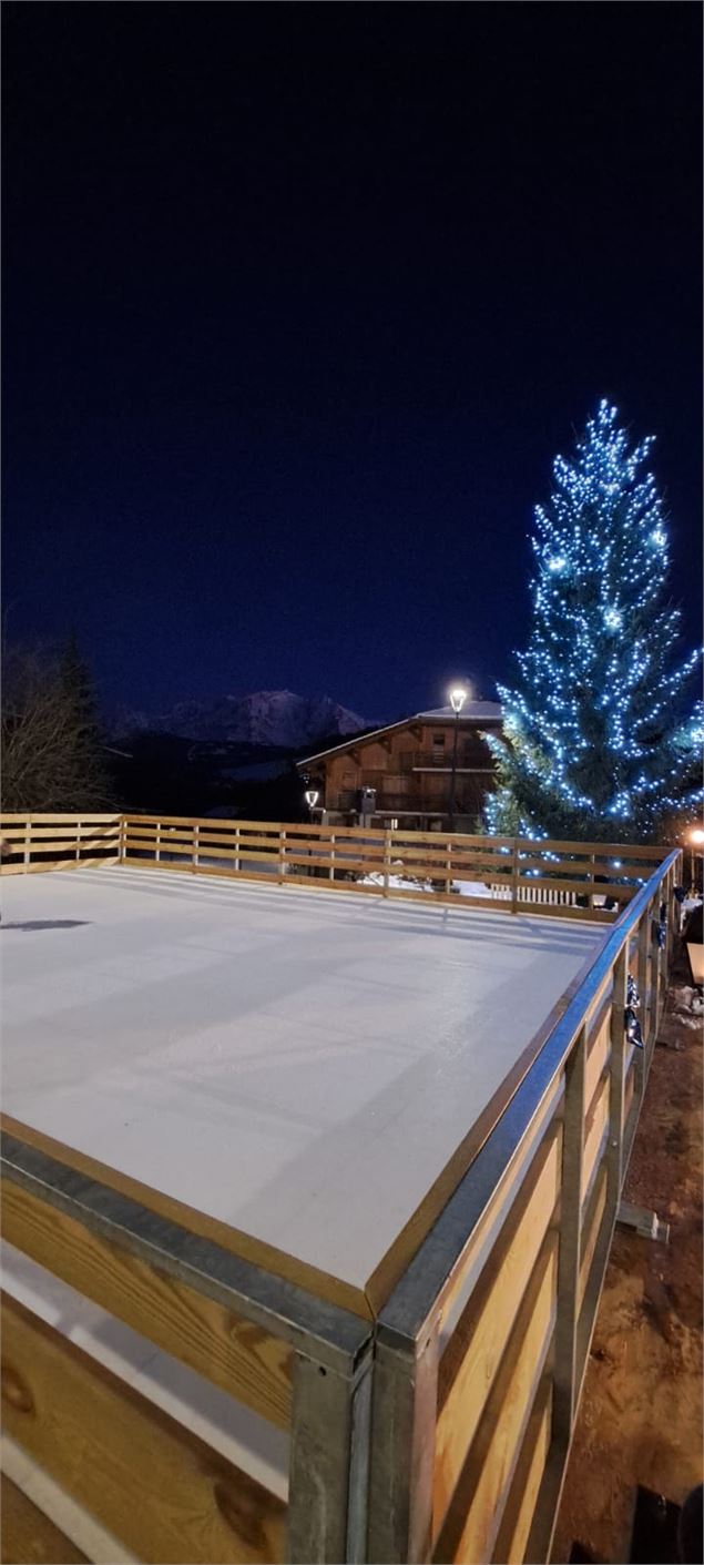 Patinoire la nuit face au sapin illuminé - Canva