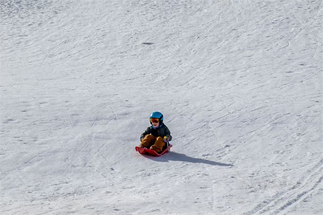 Enfant sur une luge à Albiez - OTICoeurdemaurienne