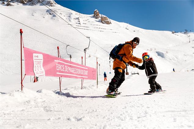 Père et fils qui descendent la piste Digues - Gregoire Fauquenoi