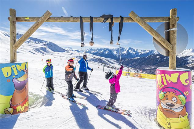 Enfants qui tapent dans les cloches disposées sur le parcours de la piste ludique la Tanière de Bori