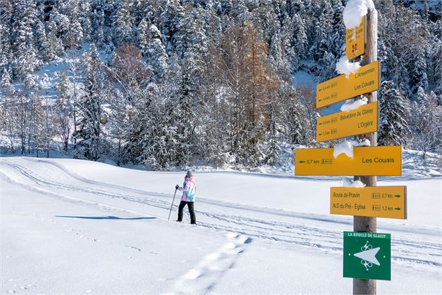 personne en raquettes et panneaux directionnels - Coeur de Tarentaise Tourisme - L. Jacquin