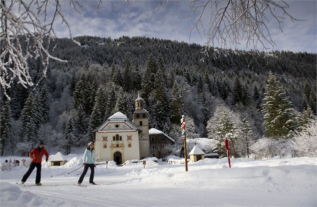 Ski de fond devant l'église de Notre-Dame de la Gorge - Les Contamines Tourisme