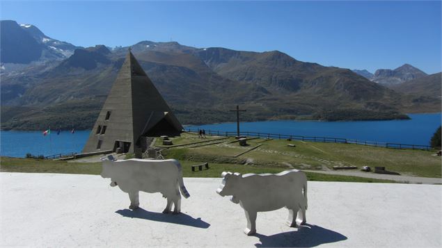 Vache en métal en premier plan avec la pyramide du Mont-Cenis en second plan et le lac au loin - K.M