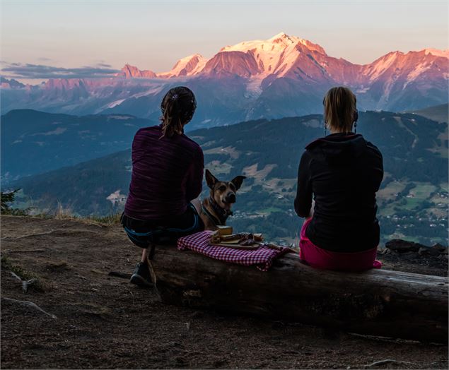 Deux randonneuses en train de pique-niquer face aux montagnes au coucher du soleil - OT Combloux_Pau