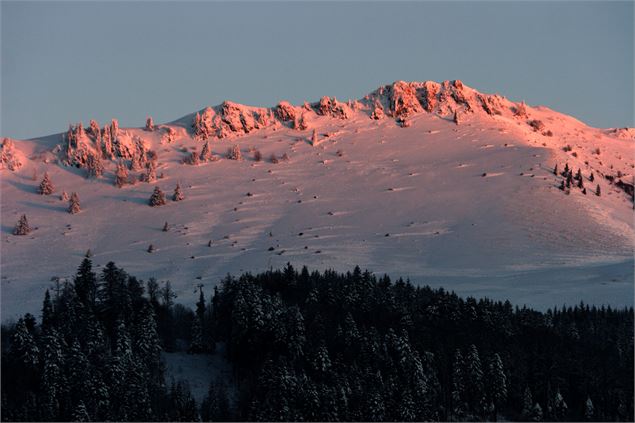 Coucher de soleil sur les crêtes enneigées.